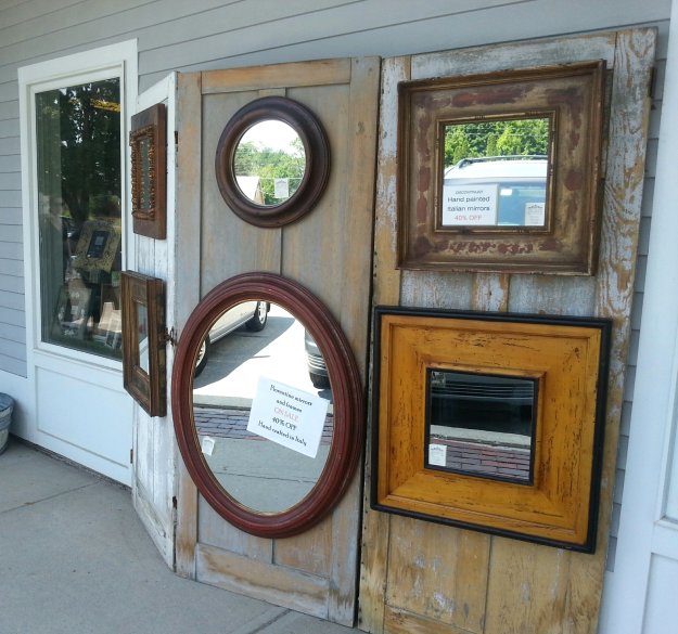 Old door panels make a fabulous backdrop to display these funky framed mirrors - Outside display at The Village Framers in Yarmouth, Maine